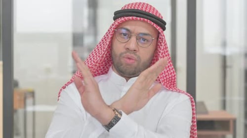 Serious Man Gestures Negatively in an Office