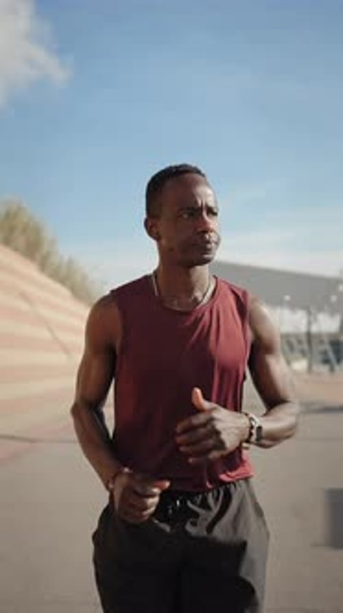 Man Running on Urban Road During Day