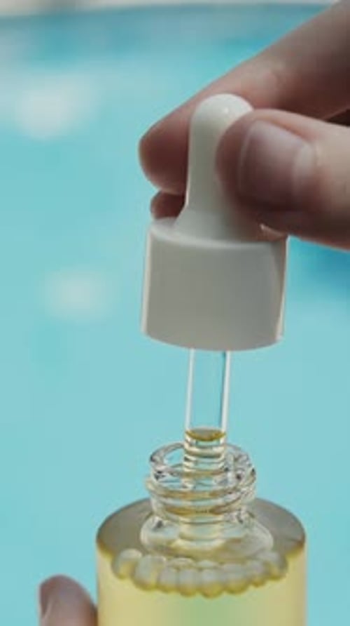 Serum Drips From Dropper Into Bottle by Pool