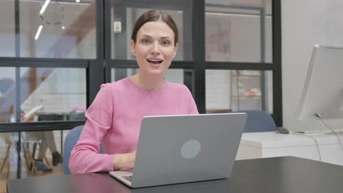 Businesswoman at Laptop Gives Thumbs Up