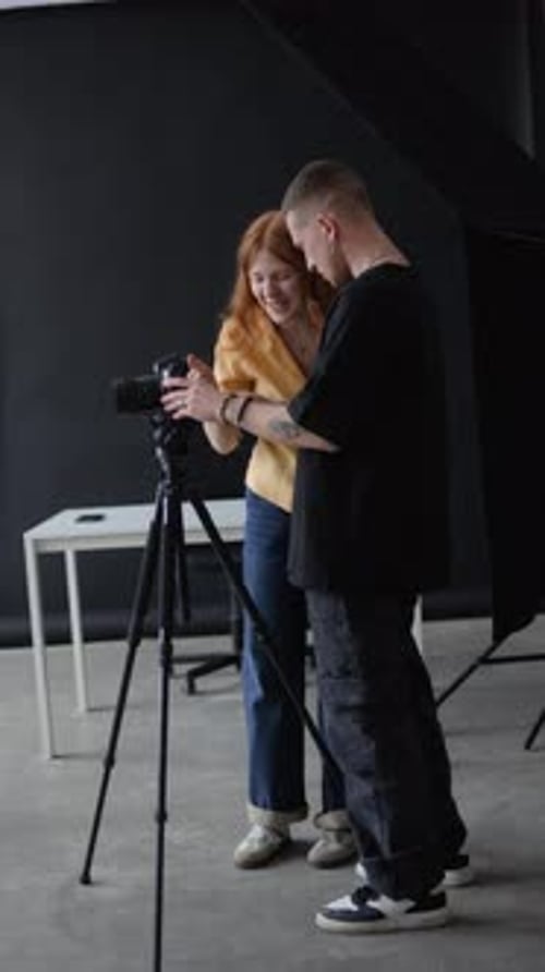 Young Man and Woman Setting Camera in Studio
