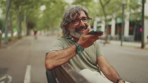 Man Using Smartphone on Park Bench
