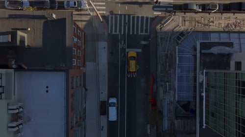 Yellow New York City Taxi Navigates Busy Intersection Weaving Past Vehicles Surrounded By Urban