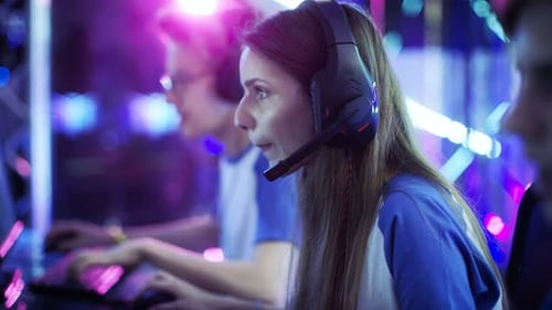 Intense Young Adults Gaming with Headsets in Competition