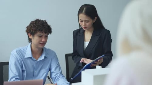 Two colleagues reviewing project details together in an office setting