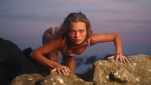 Woman Crawls on Beach Rocks at Sunset Embodying Wild Primal Energy In Slow Motion She Navigates