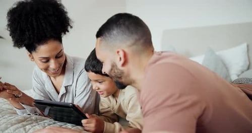 Family Using Tablet Together on Bed at Home