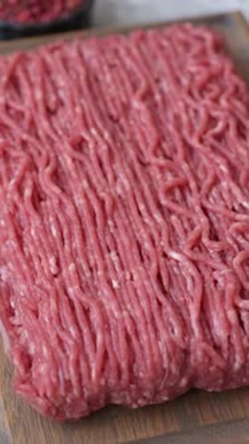 Raw ground beef or pork for burgers or meatballs with salt and spices. Raw ground beef