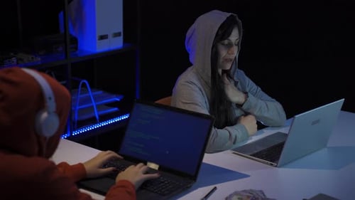 Hacker is working on laptop in a stressed and excited state.