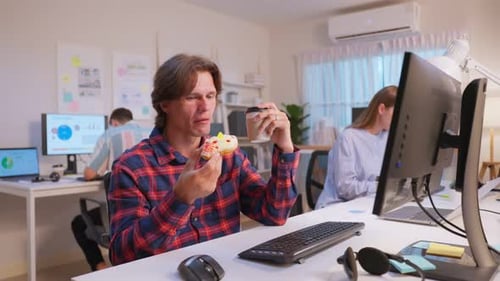 Group of business person eating doughnut while working in the office.