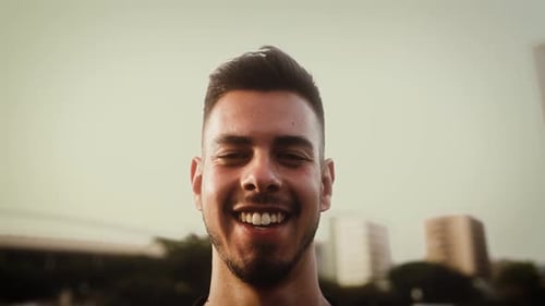 Happy young man smiling in front of camera in the city