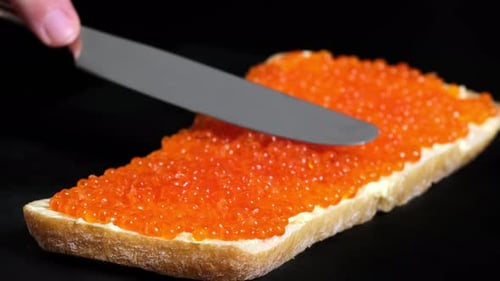 Caviar Being Spread on Bread with Knife