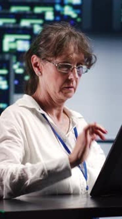 Woman Using Tablet in Dark Tech Office