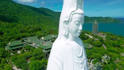 The Majestic Lady Buddha Statue Overlooks Lush Greenery and Serene Waters Embodying Spiritual