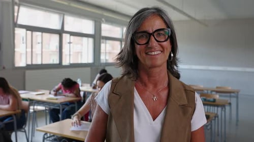 Teacher Smiles as Students Work in Classroom