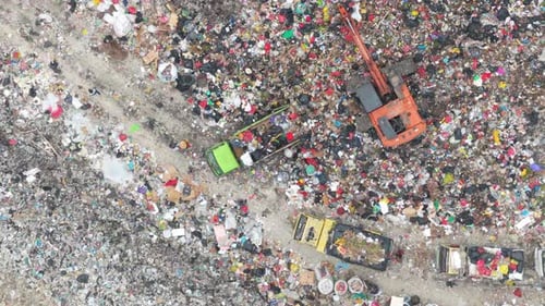 Aerial view of excavator working at garbage landfill dump in bali