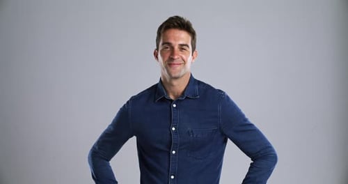 Face, happy and a handsome young man in studio isolated on gray background to relax while feeling
