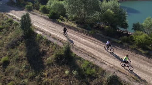 Aerial View Of Group Of Men Cycling By Lake
