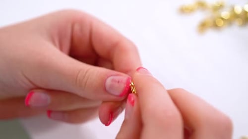 Hands Assembling Jewelry With Jump Rings and Clasp