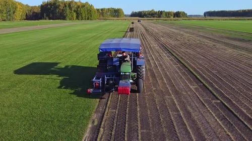 A Beautiful Aerial View Showcasing Agricultural Machinery Removes the Lawn in Action Across Vast