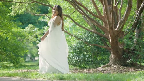 Woman in White Dress Twirling in Forest Glade