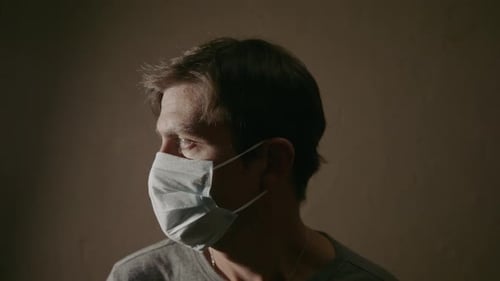 Adult Wearing Surgical Mask Looking at Camera