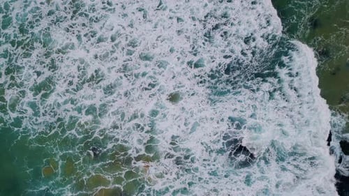 Top View Rough Waves Crashing on Coastal Rocks
