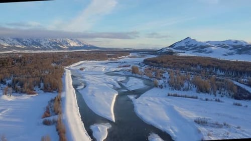 Scenic winter drone view of snow covered mountains and streams in Wyoming