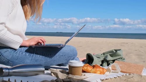 Junge Frau arbeitet am Laptop am Strand neben Sea Ocean View