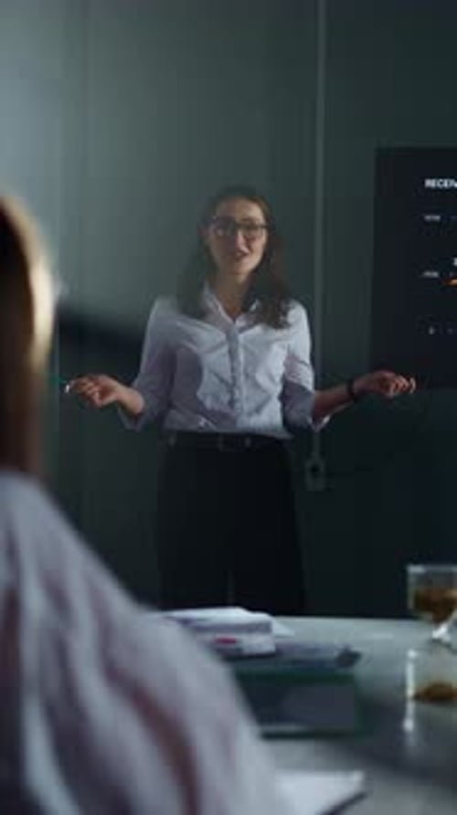 Woman Giving Presentation in Office, Discussing Sales Data