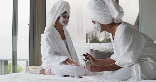 Vídeo de amigas felizes e diversificadas hidratando com máscaras faciais e pintando unhas