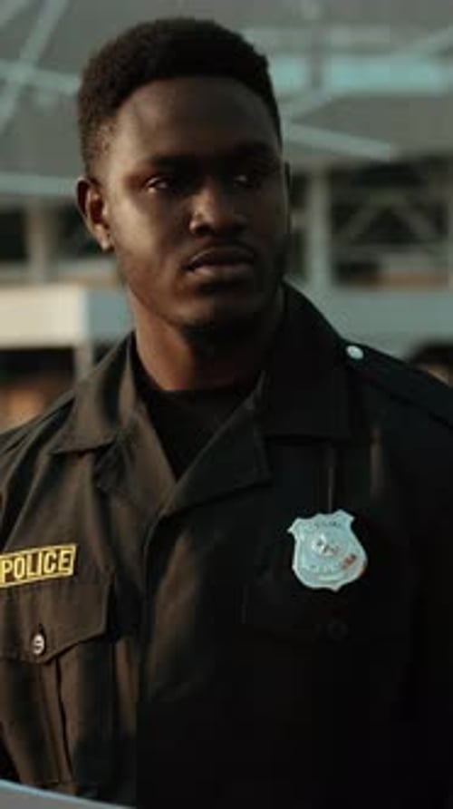 Young Police Officer Takes Notes in Urban Setting