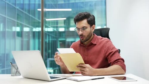Man Reacts to Paperwork at Modern Office Desk