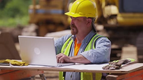 Construction Worker Using Laptop Computer Backhoe