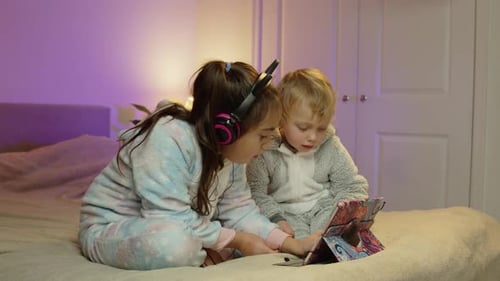 Children Learning With Tablet On Bed Watching Cartoons And Reading Ebooks