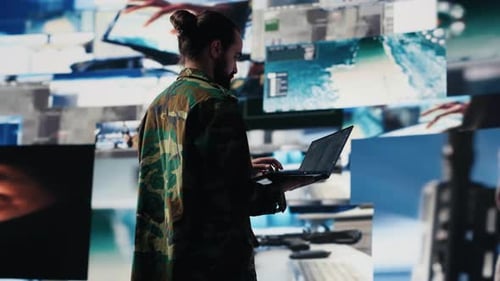 Man in Camo Analyzing Data on Laptop