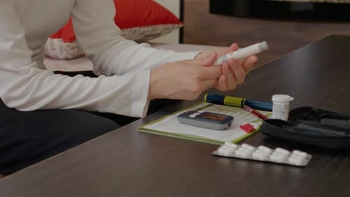 Mulher demonstra teste de açúcar no sangue usando uma técnica de glicosímetro e caneta