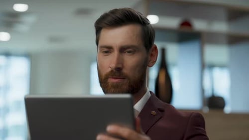 Happy Businessman Using Tablet in Office Closeup