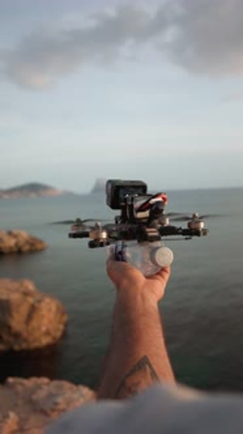 Zumbido portátil FPV que despega sobre rocas costeras