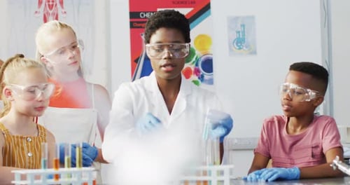 Diverse female teacher and happy schoolchildren having science class in school lab