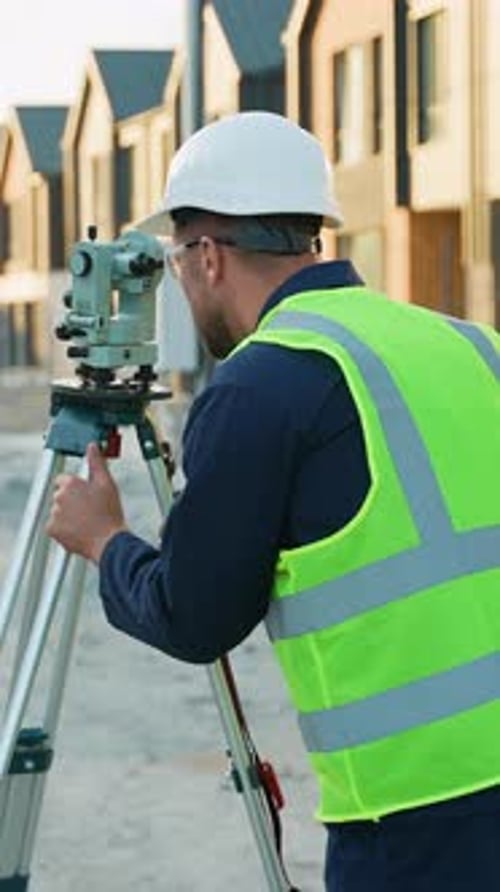 Construction Worker Using Level at Building Site