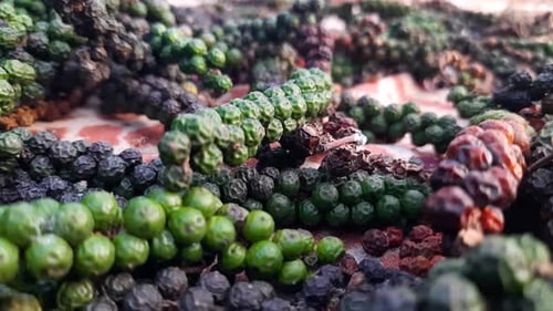 Close up zoom in shot of colorful peppercorns drying in open air