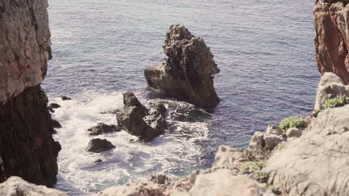 a giant rock with crystal clear water moving around in portugal