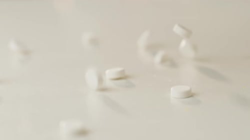 Slow Motion Close Up of Pills Falling on Table
