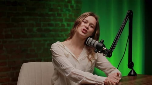 Woman Speaking into a Microphone in a Studio