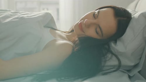 Woman Sleeping Peacefully in Bed in the Morning