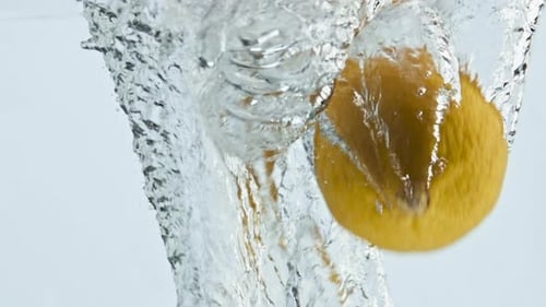 Fresh lemon splashing into clear, clean water