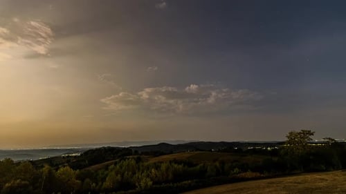Time-lapse of Sunset to Starry Night over Forest and Villages from Hilltop