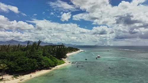 An aerial view of a beach with boats in the water