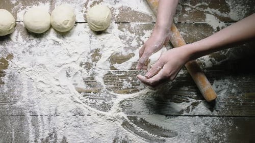 Hands Kneading Dough on Wooden Kitchen Surface